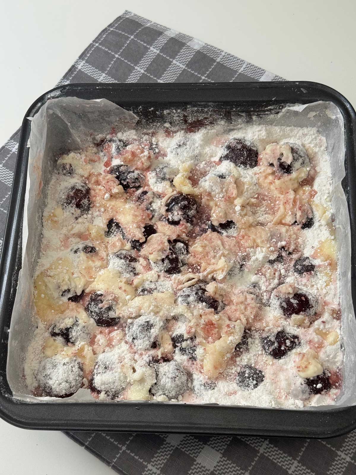 An unbaked Cha-Cha-Cha Cherry Cake in a square pan.