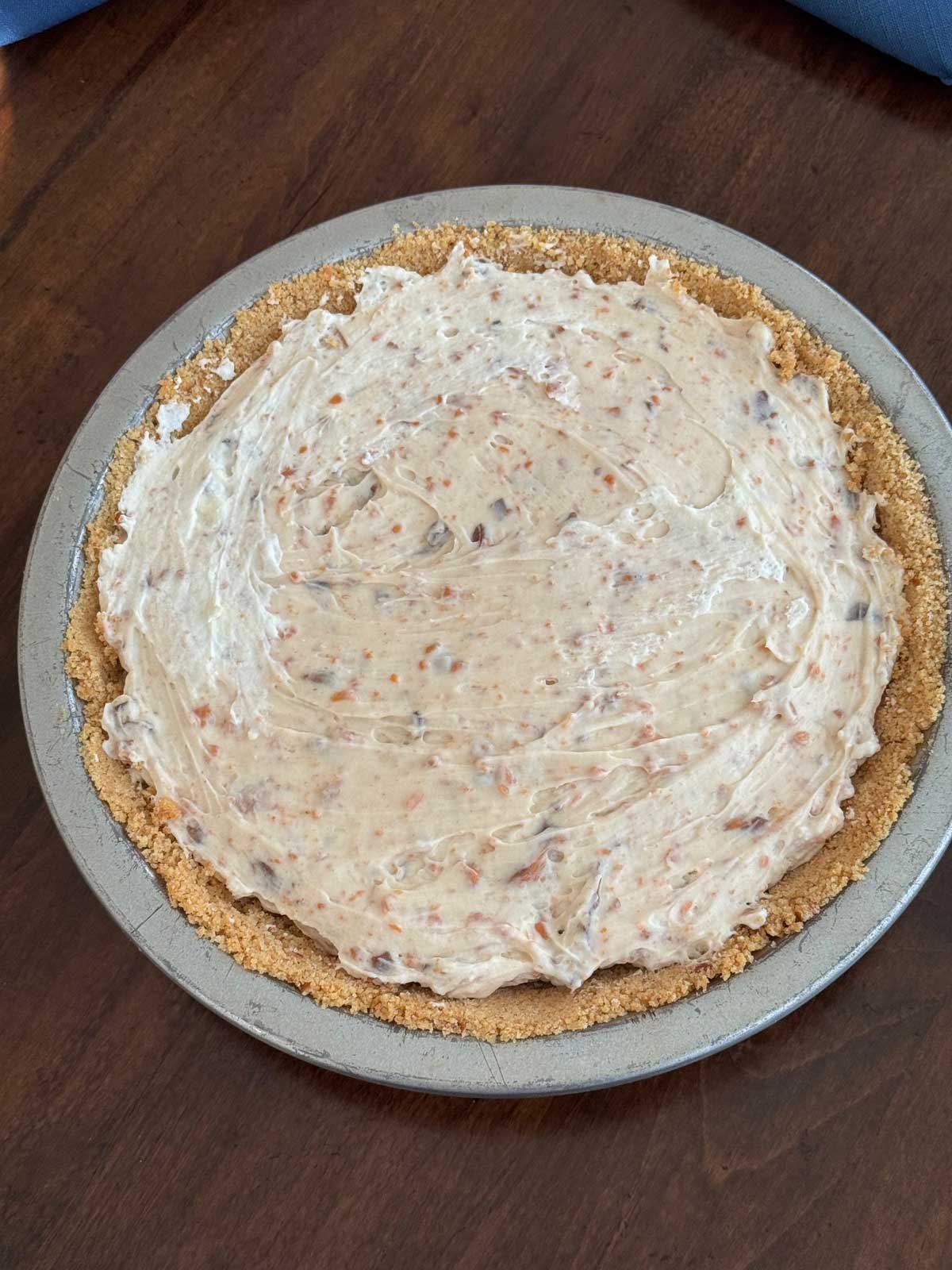 A creamy Butterfinger pie waiting for a topping of whipped cream.