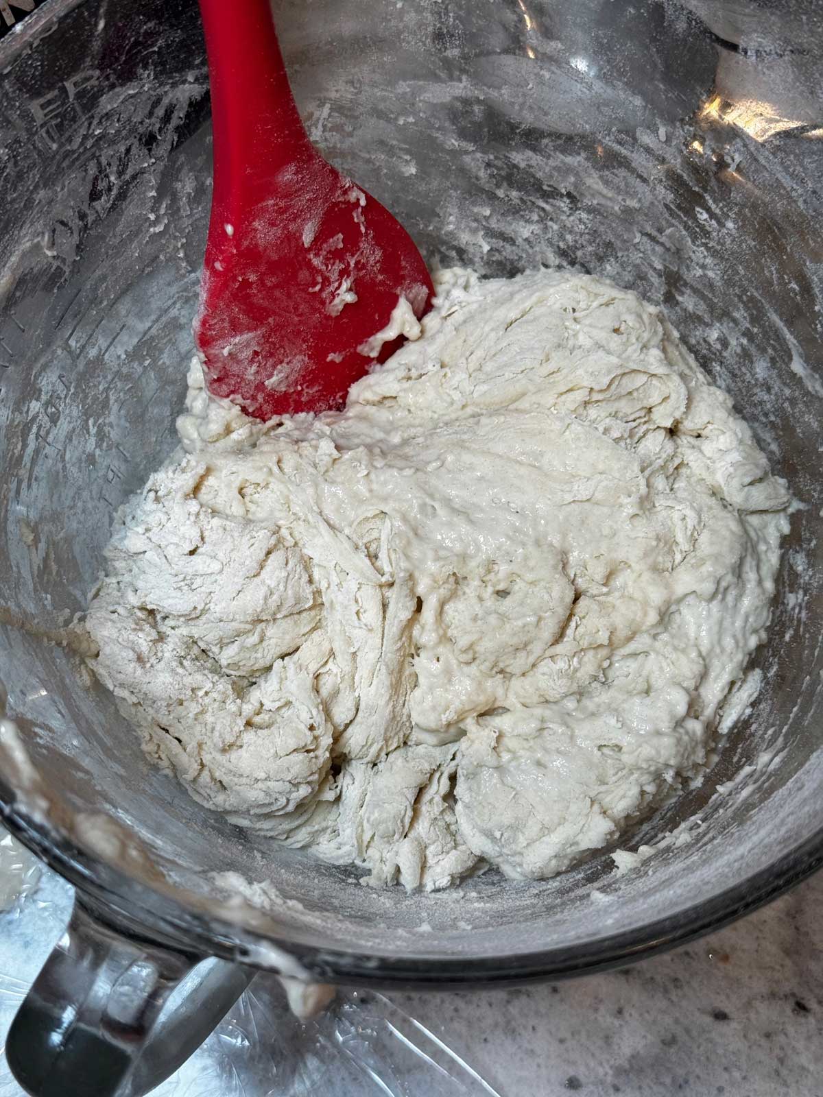 Flour, water and sourdough being mixed in bowl for one day sourdough bread recipe.