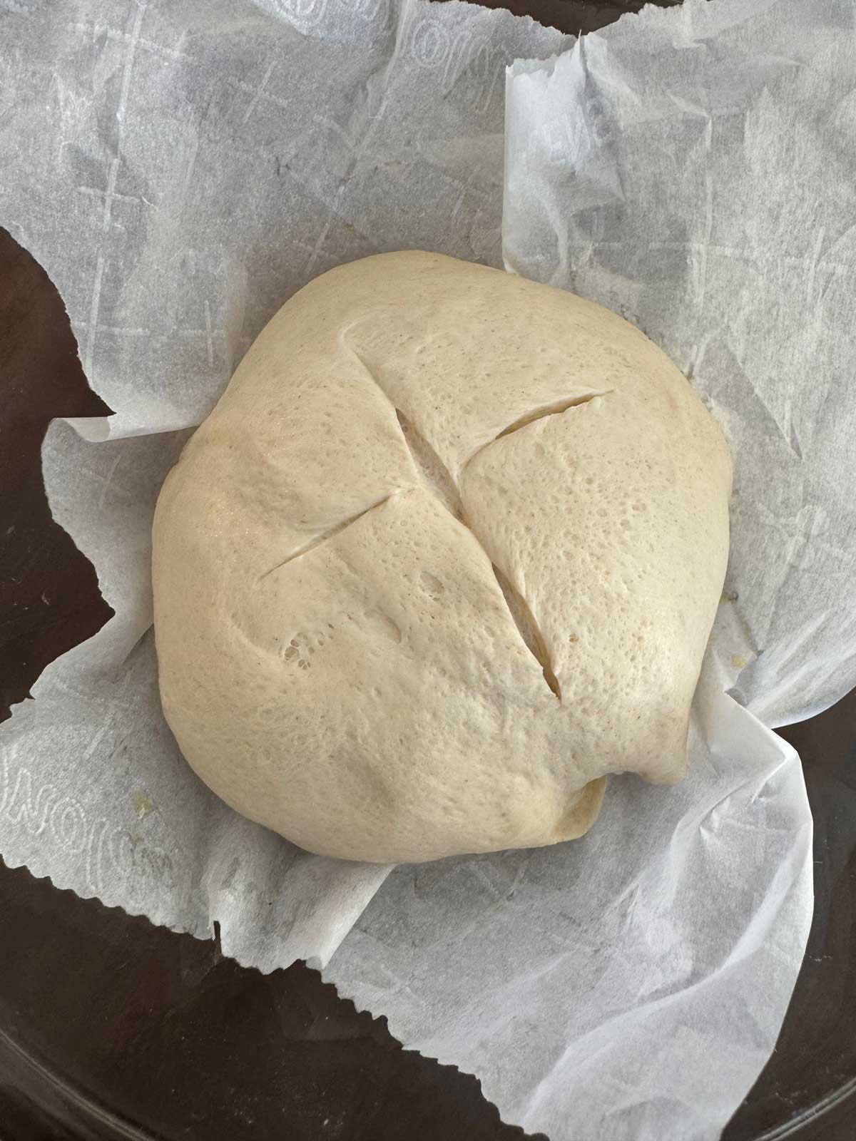 Sourdough discard boule ready to get dropped into the hot Dutch oven, parchment and all.
