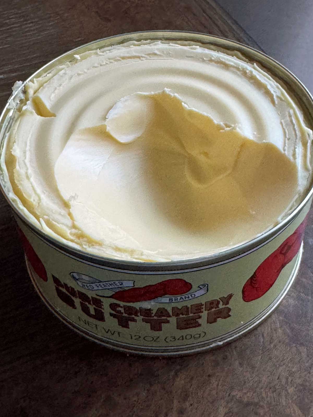 An opened can of Red Feather butter