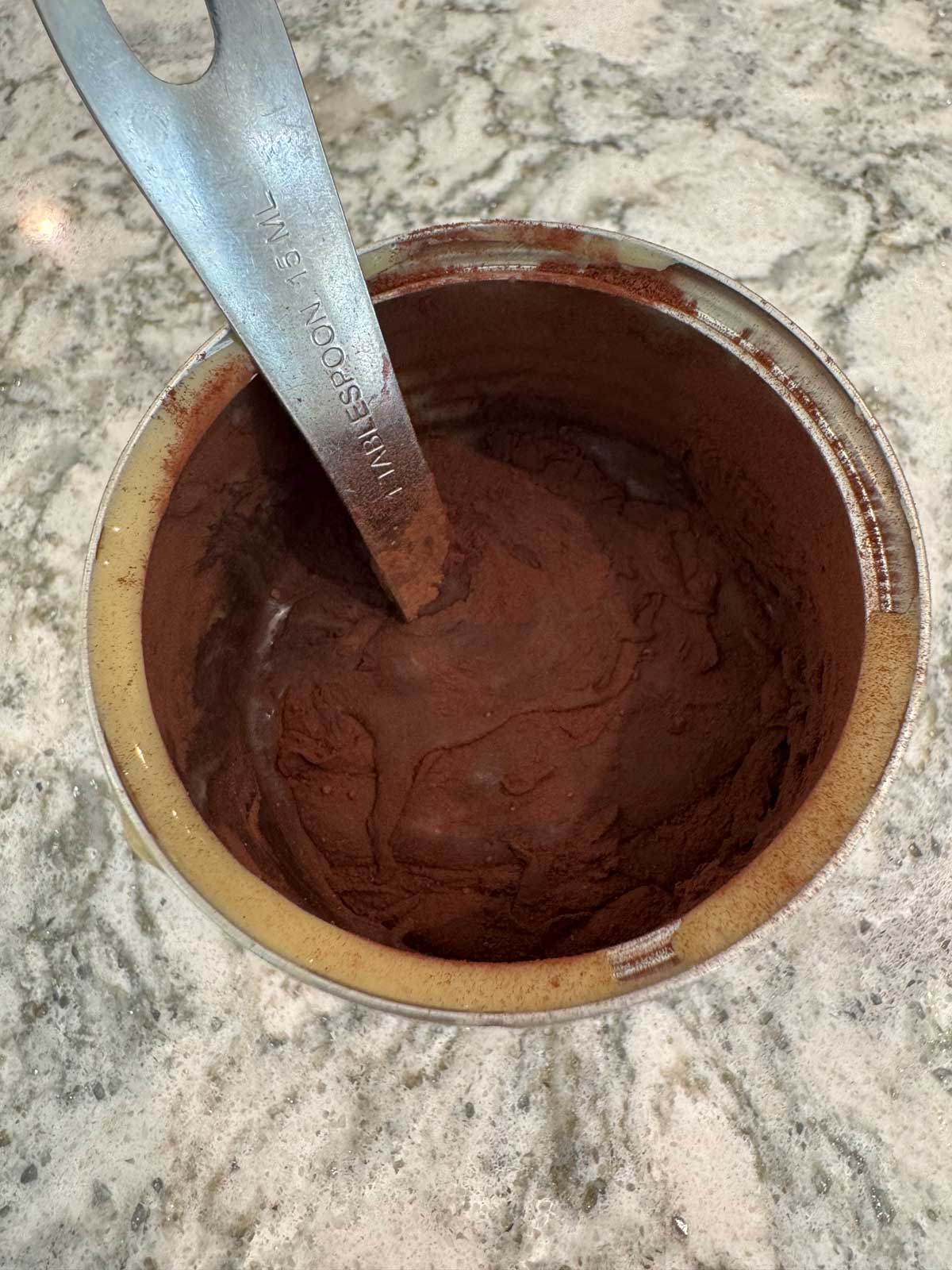 Mixing cocoa powder into half a can of condensed milk to make no-churn chocolate ice cream.