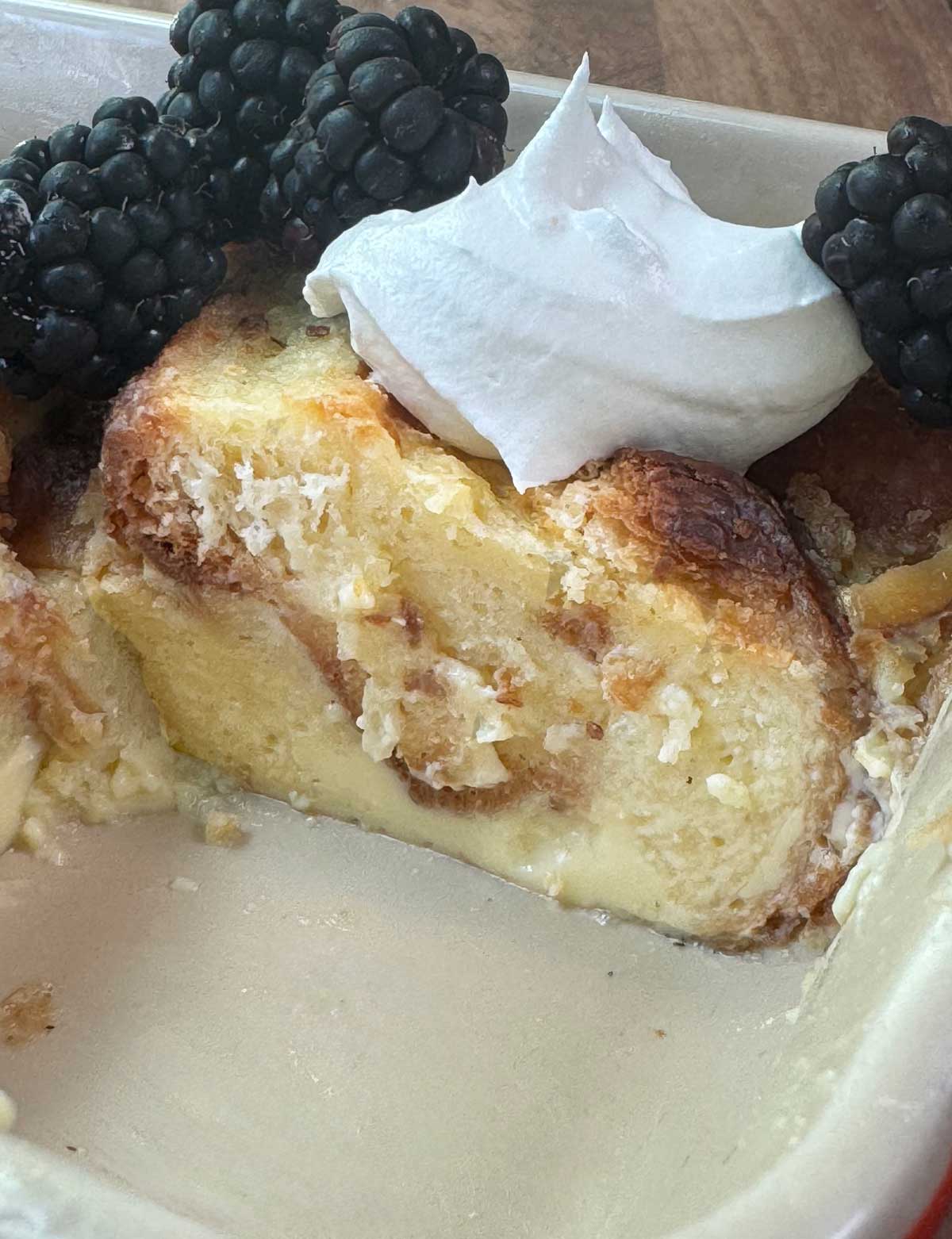 Croissant Bread Pudding for Two recipe served with whipped cream and blackberries.