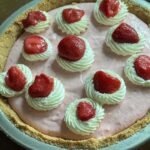Strawberry Cream Pie garnished with whipped cream and frozen thawed strawberries.