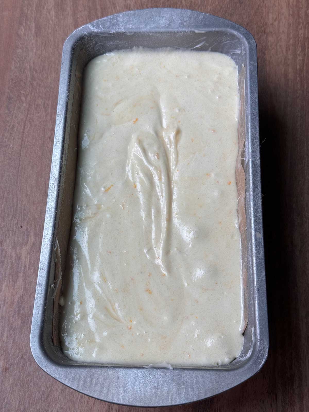 Orange loaf cake batter in an 8x4 inch metal pan