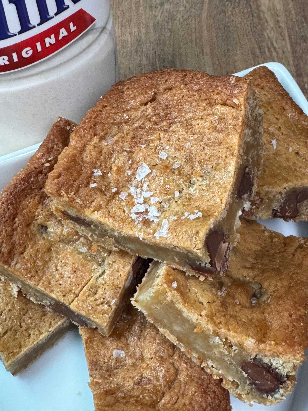 Malted Milk Powder Blondies with sea salt sprinkled on top and milk