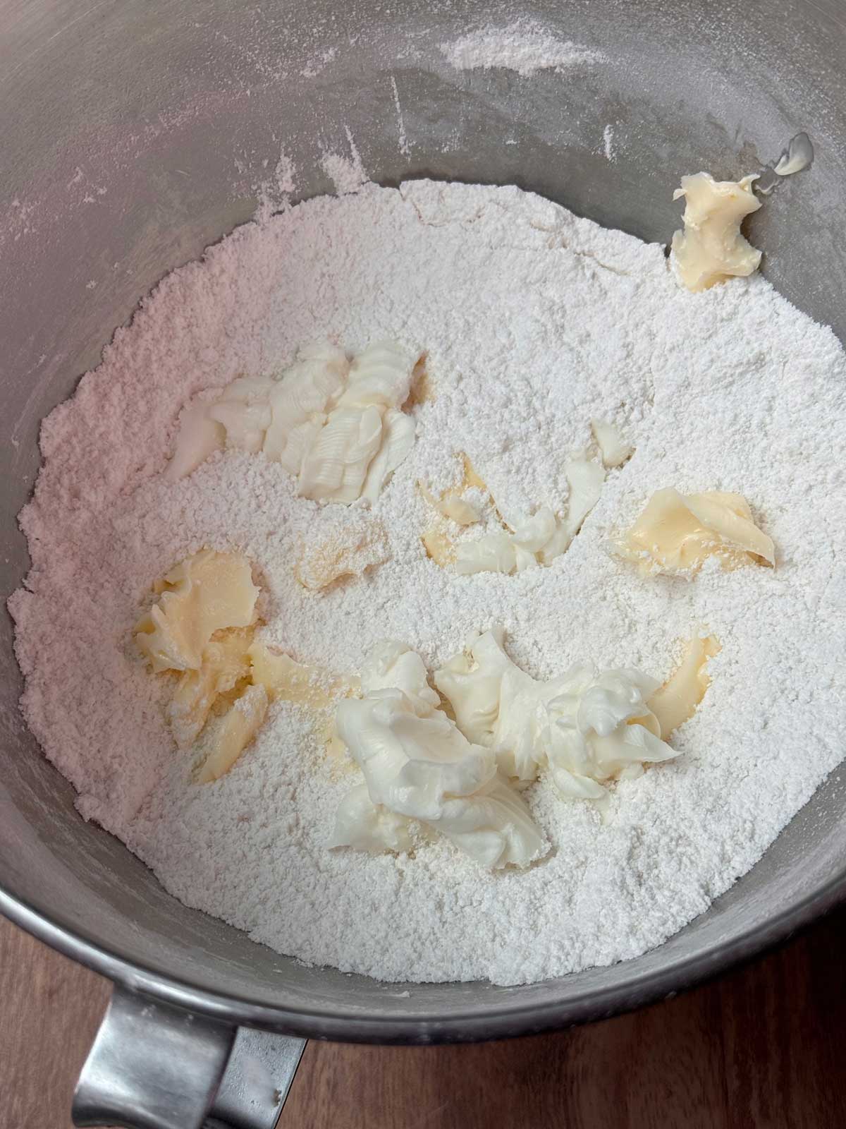 reverse creaming method showing shortening and butter scattered over flour, sugar, salt and baking powder mixture.